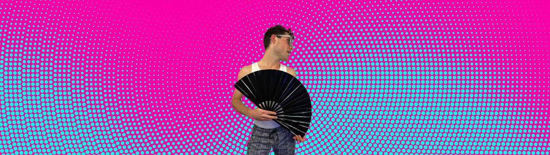 Man holding a silver metallic clack fan at a circuit party