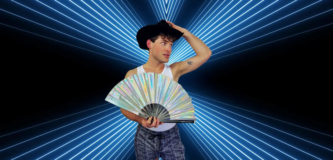 Man holding a silver metallic clack fan at a circuit party