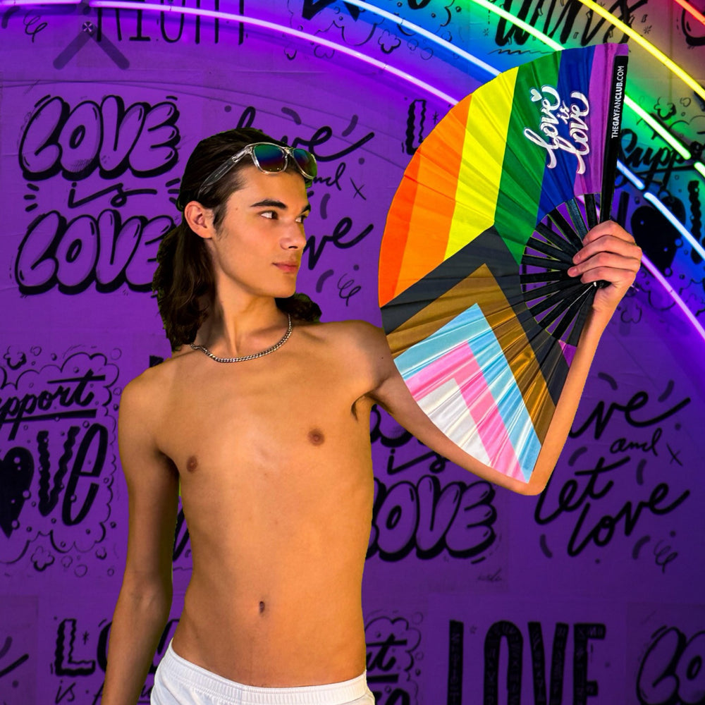 Model holding an Oversized Classic Rainbow Flag Bamboo Clack Fan for Pride Parades and LGBTQ+ Rallies