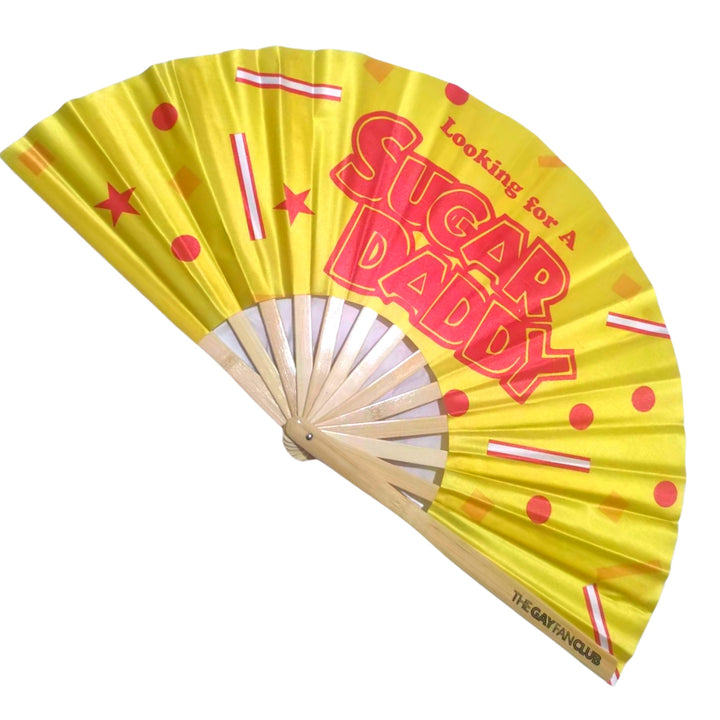 Oversized Bamboo Clack Fan with "Looking for a Sugar Daddy" Text in Red on a Bright Yellow Fabric