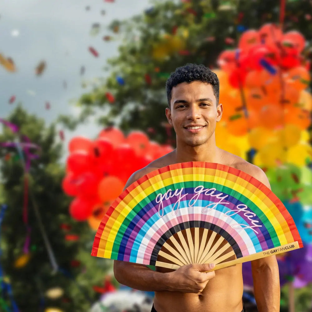 Man holding a rainbow fan with 'gay gay gay' text against a colorful background