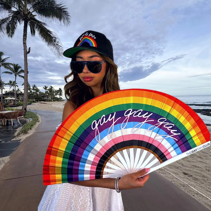 Person holding a rainbow fan with &