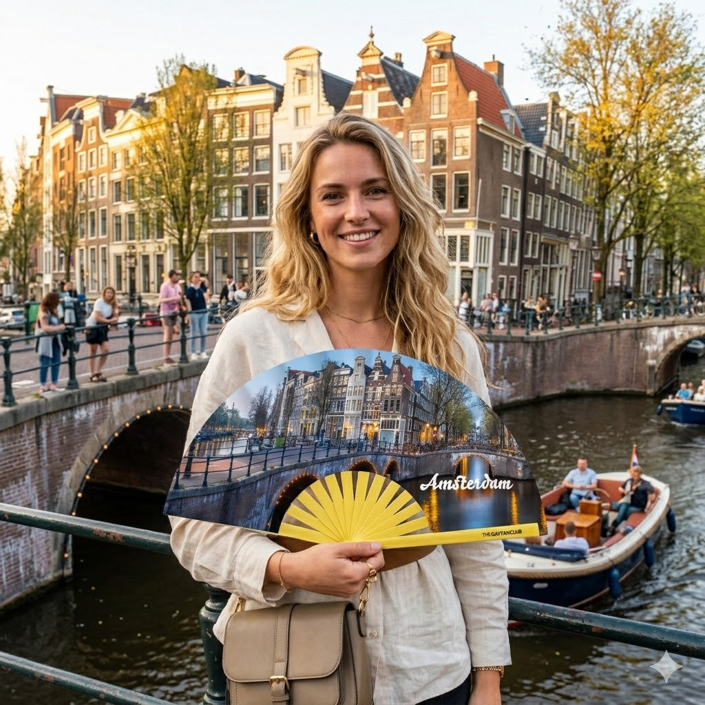 Amster-Damme Diva Fan fully open showing the Amsterdam, Netherlands canal house skyline and city lights on a natural bamboo frame.