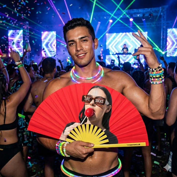 A person at a rave snapping the Best Life Fan open for a loud clack while serving a fierce look.