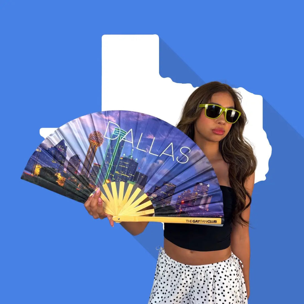 Woman holding a fan with Dallas design against a blue background