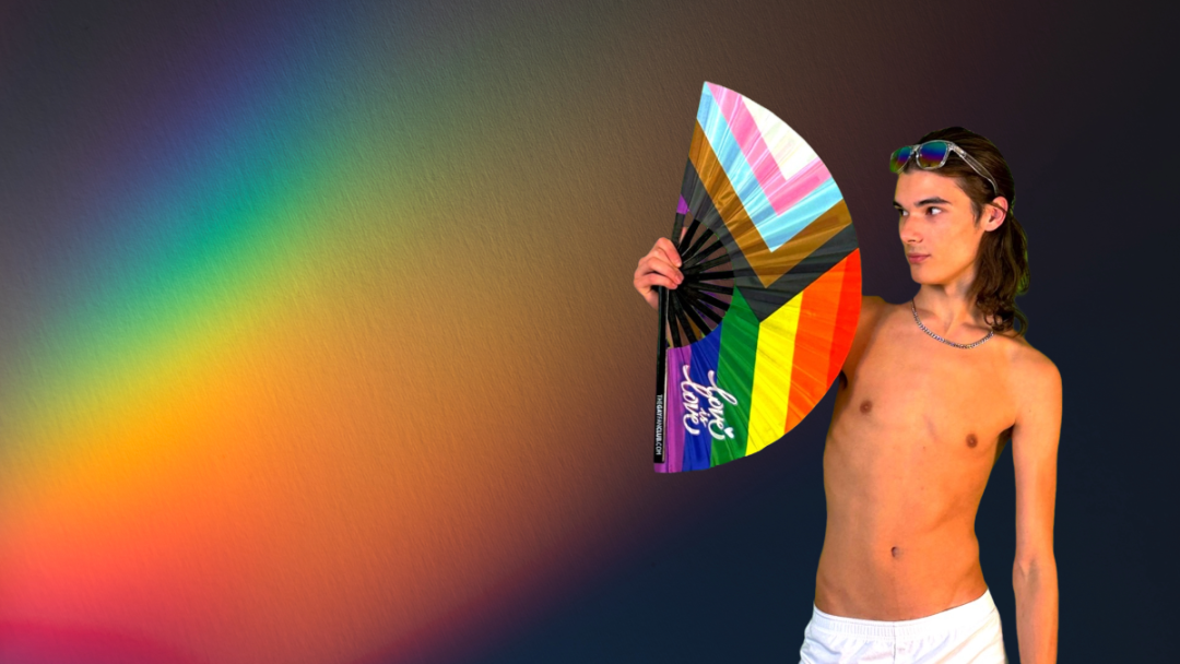Man holding a Pride Rainbow Hand Fan from The Gay Fan Club against a black rainbow background