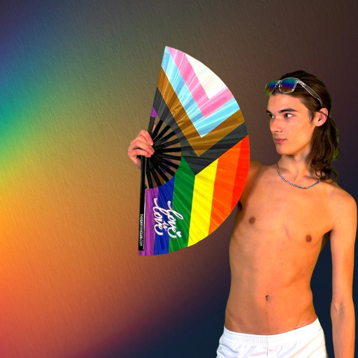 Man holding a rainbow clack fan oversized from The Gay Fan Club