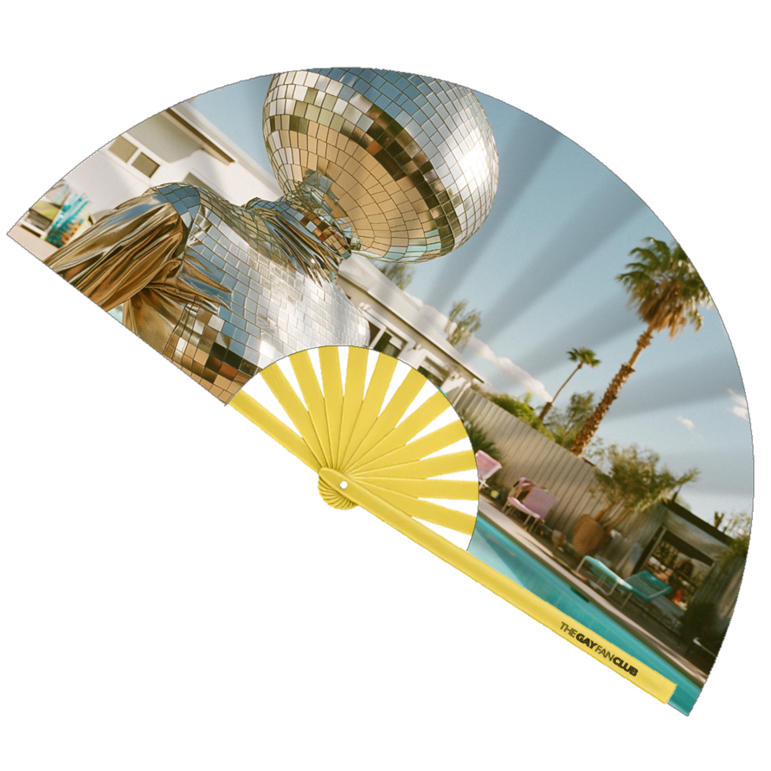 Disco Diva Fan fully open showing a surreal figure with a disco ball head in a silver suit lounging by a Palm Springs pool, set against yellow bamboo ribs