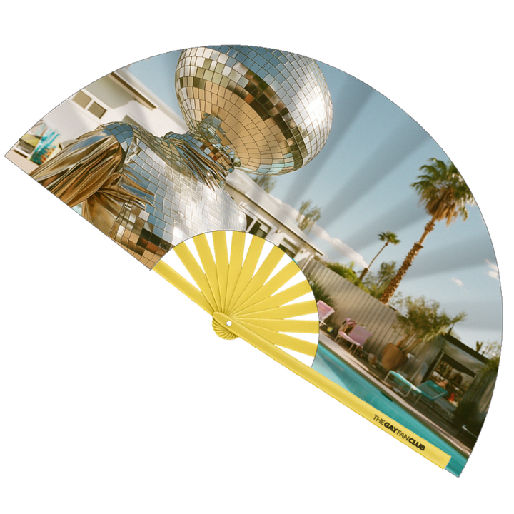 Disco Diva Fan fully open showing a surreal figure with a disco ball head in a silver suit lounging by a Palm Springs pool, set against yellow bamboo ribs