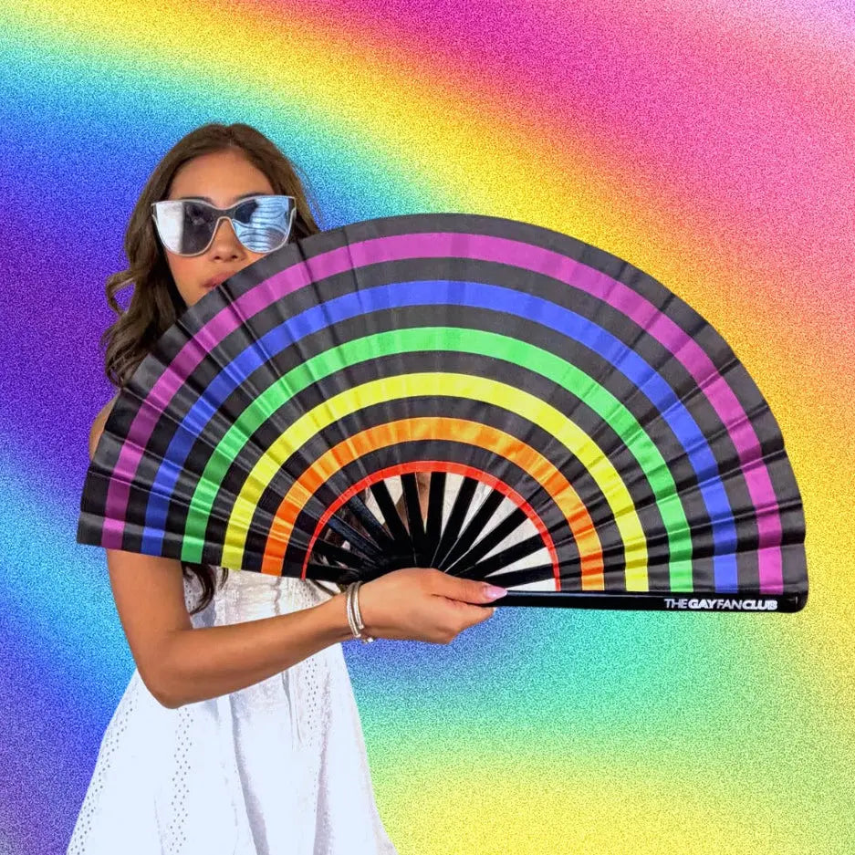 Woman holding a rainbow-colored fan against a colorful gradient background