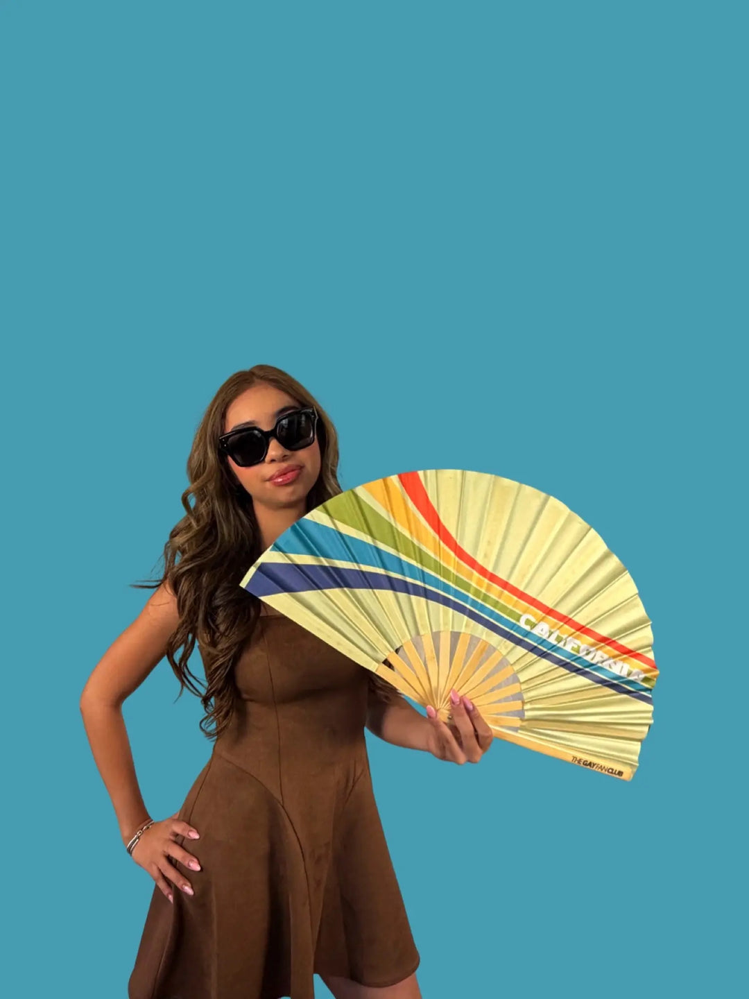 Woman holding a colorful fan against a blue background