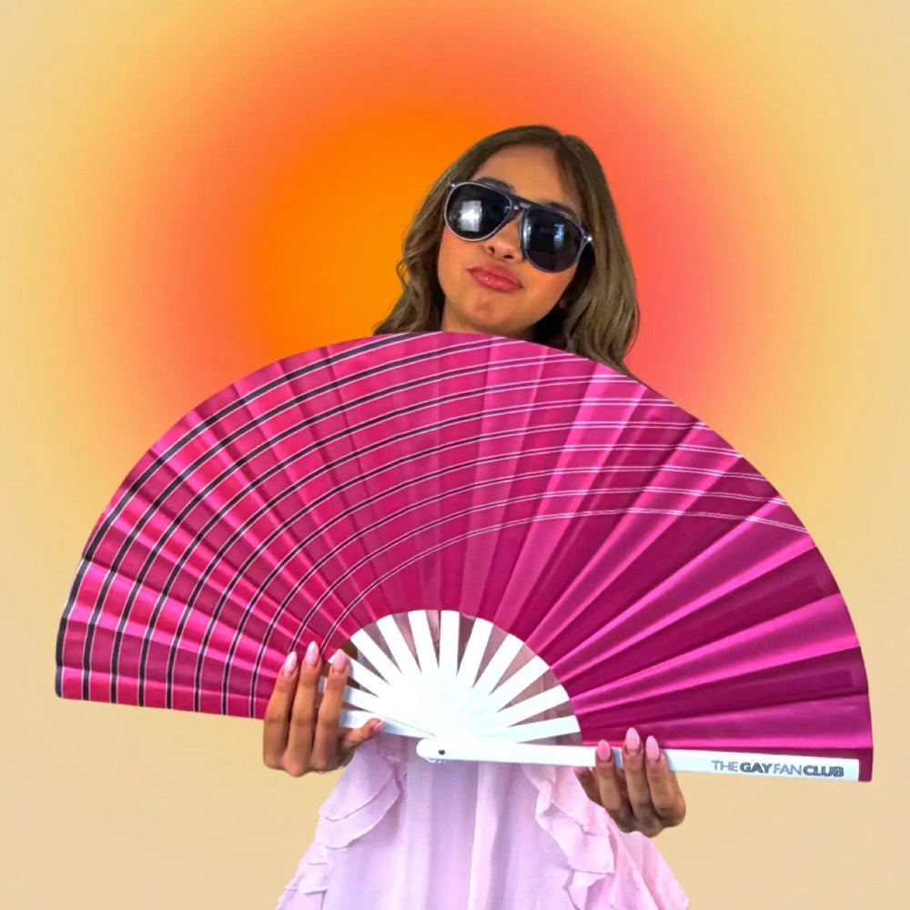 Woman holding a pink and white fan against a gradient background