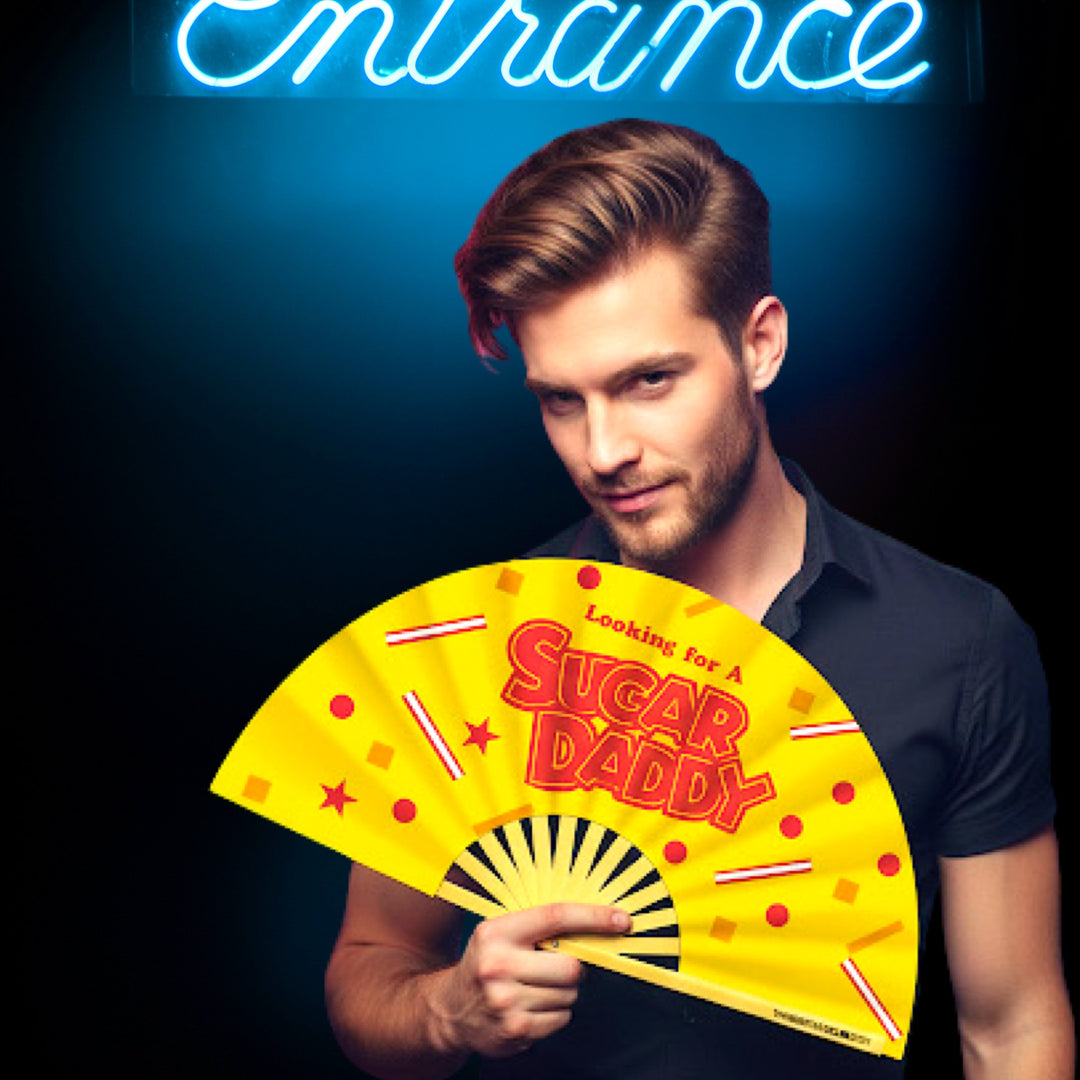 Oversized Bamboo Clack Fan with "Looking for a Sugar Daddy" Text in Red on a Bright Yellow Fabric