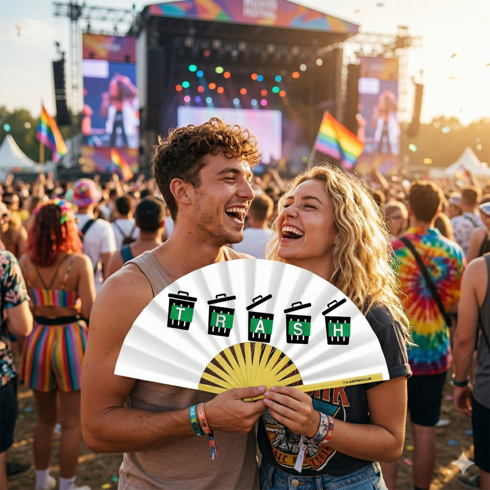 Two people at a music festival holding a 'White Trash' bamboo clack fan